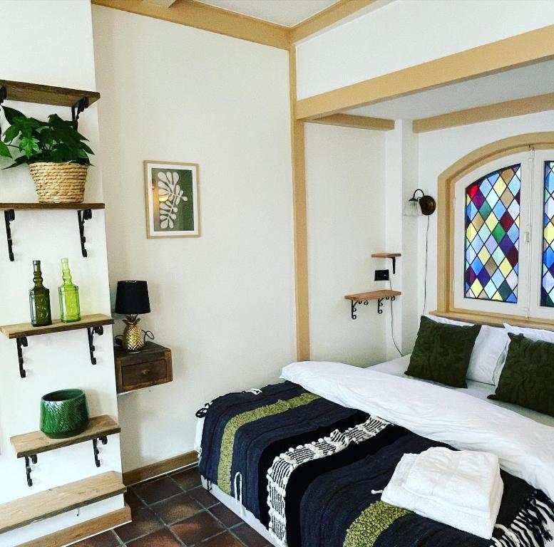 哈萊姆的住宿－Toast by night，一间卧室设有一张床和一个彩色玻璃窗