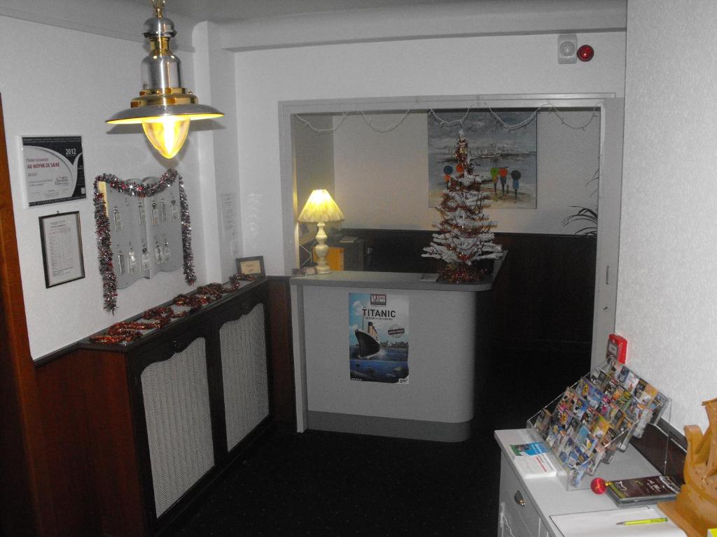 a room with a kitchen with a christmas tree on the counter at Hotel au Moyne De Saire in Réville