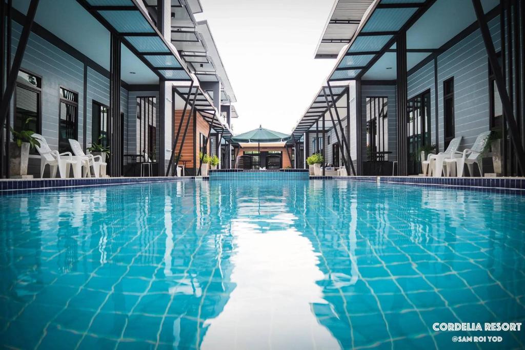 a swimming pool with blue water in a building at Cordelia Resort Sam Roi Yot in Sam Roi Yot