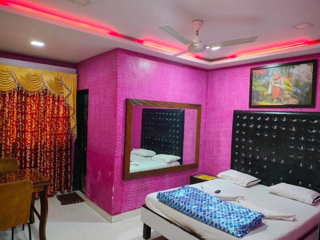 a room with a pink wall with a bed and a mirror at Spring Resort & lodging in Mumbai