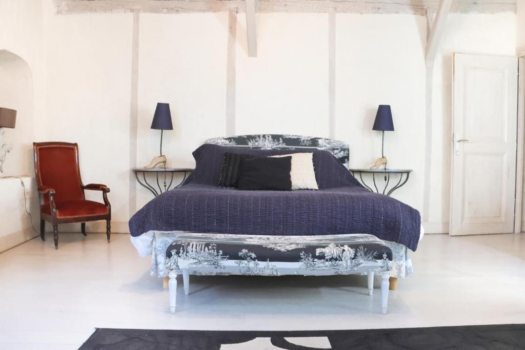 a bedroom with a bed and a chair and windows at Maison de la Pra in Valence