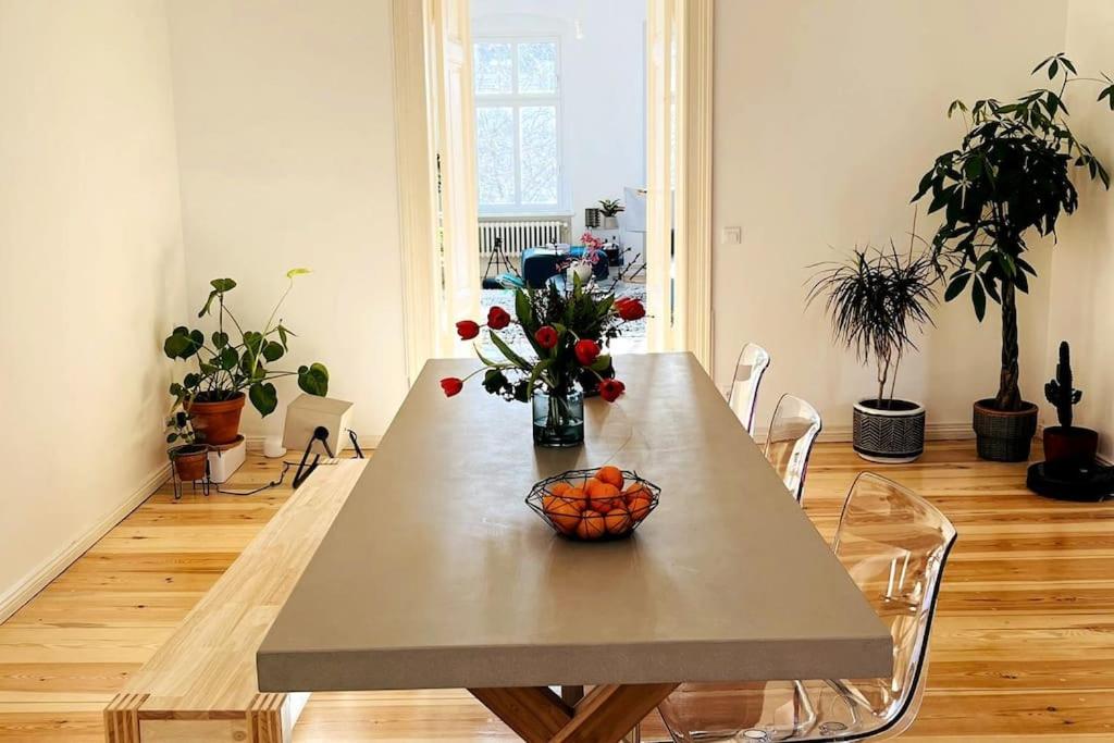 a table with a vase of oranges and flowers on it at Dreamy Apartment in Kreuzberg - 130m2 in Berlin