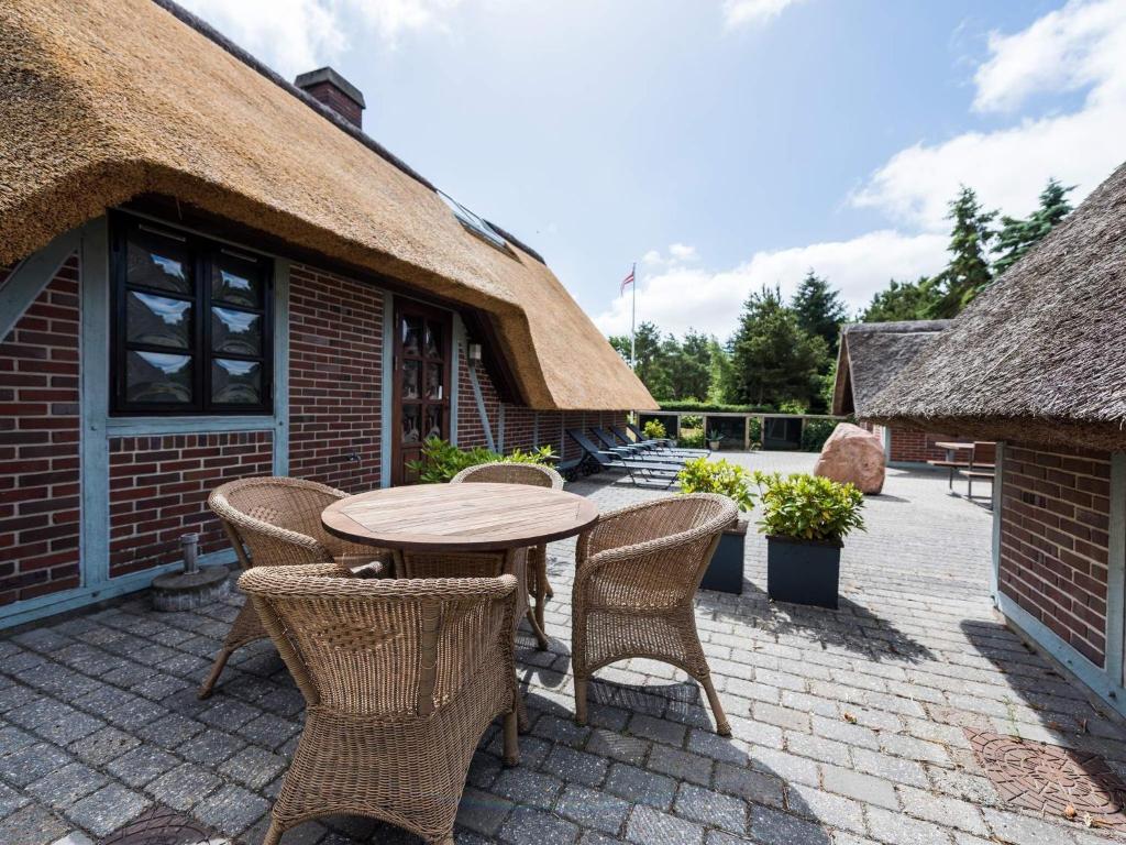 a patio with a table and chairs and a building at Holiday home Nørre Nebel LVII in Nørre Nebel