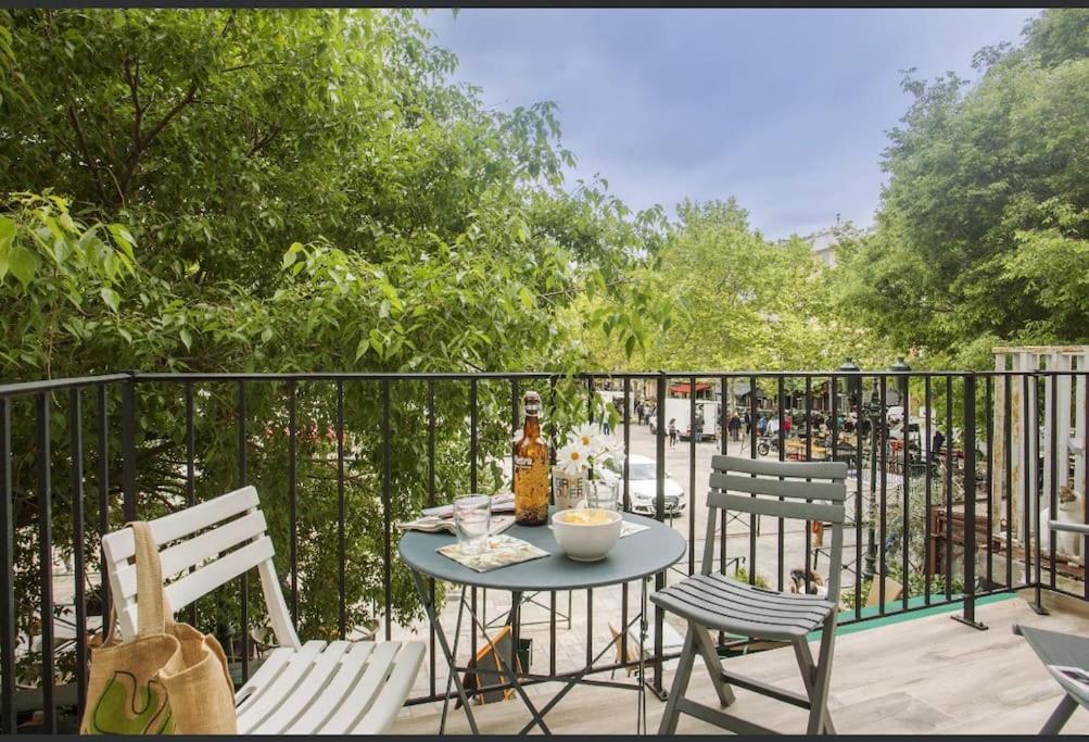 een tafel met 2 stoelen en een fles wijn op een balkon bij Pépite Bastiaise Place du Marché in Bastia