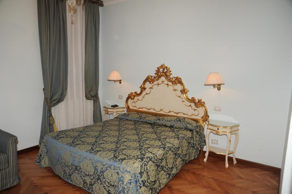 una camera con un letto e due tavolini di Alloggi Santa Sofia a Venezia