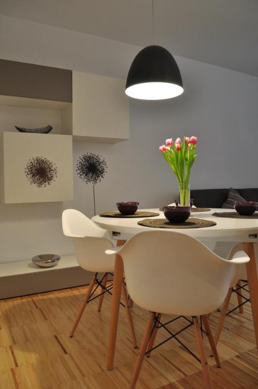 a dining room with a table and chairs with flowers on it at Apartments City&style in Zagreb