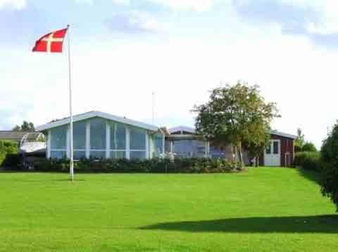 uma casa com uma bandeira no meio de um quintal em Strandhuset. em Asperup
