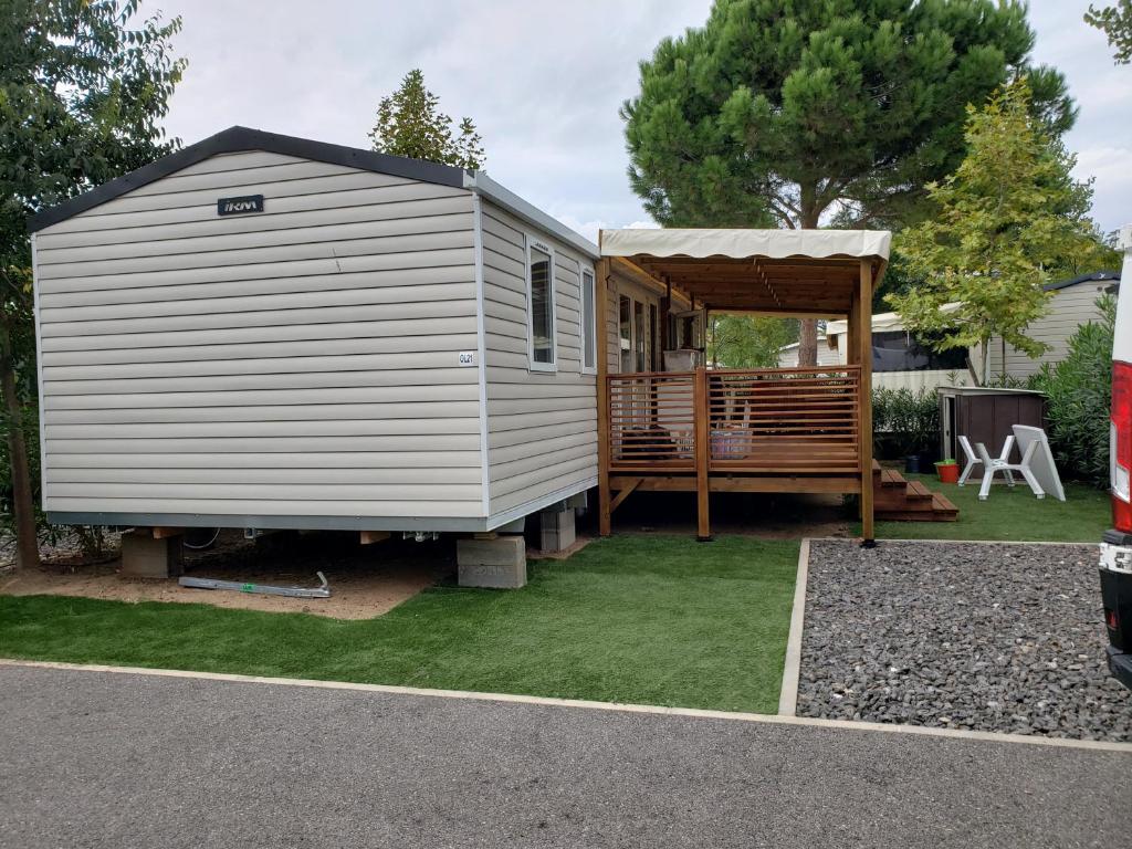 a large white tiny house with a gazebo at CAMPING SIBLU LA CARRABASSE MOBIL HOME OL21 in Vias