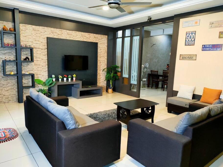 sala de estar con 2 sofás y TV en 678 homestay 4 room 5 minutes to tower, en Teluk Intan