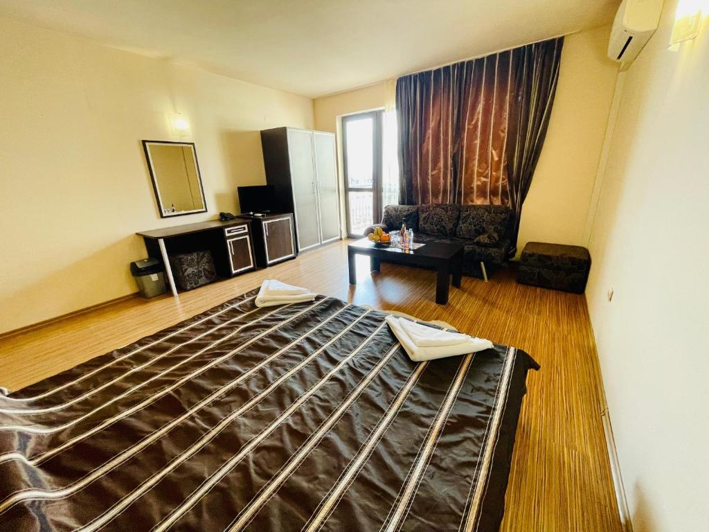 ein Schlafzimmer mit einem Bett und ein Wohnzimmer in der Unterkunft At the American's Hotel in Pomorie