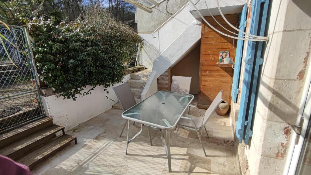 a glass table and chairs sitting on a patio at La Chaumière de Chaumont in Chaumont-sur-Loire