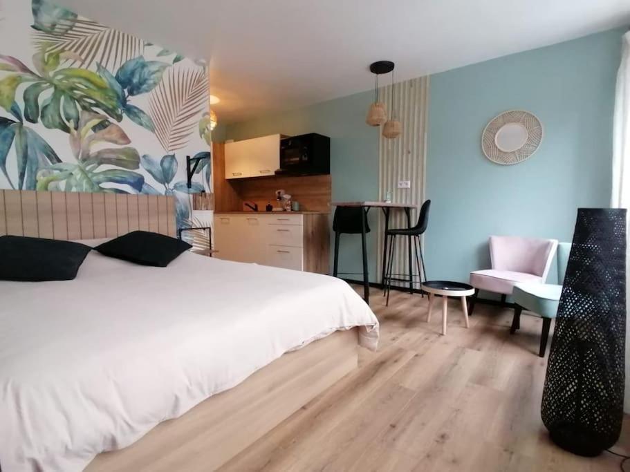 1 Schlafzimmer mit einem Bett, einer Küche und einem Tisch in der Unterkunft Studio neuf - parking - 3 Epis proche Turckheim in Turckheim