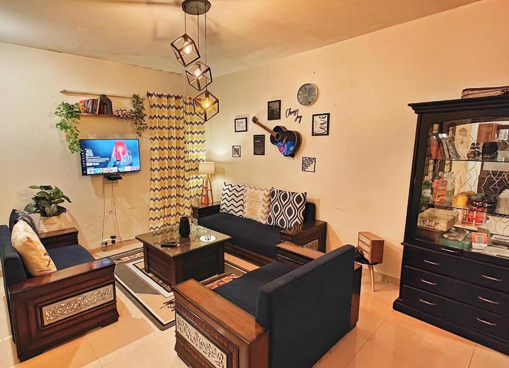 a living room with a couch and a tv at Meraki - Entire 3BHK Villa With Himalayan Views in Rānīkhet