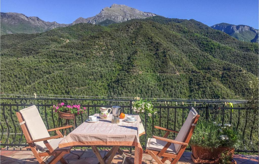 una mesa y sillas en un balcón con una montaña en Pet Friendly Home In Castel Vittorio With Kitchen, en Castel Vittorio