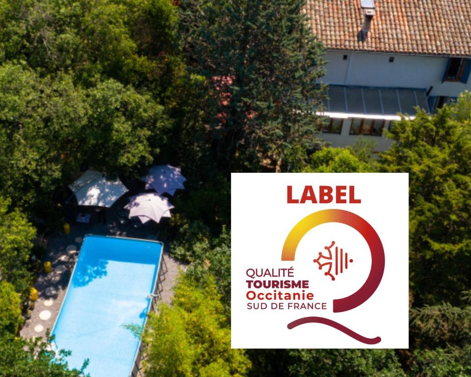 a sign in front of a swimming pool with a building at Le Portel des Arnaud Chambres d'Hôtes in Durfort-et-Saint-Martin-de-Sossenac