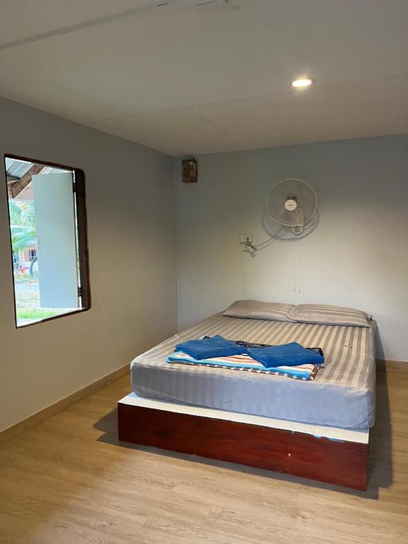 1 dormitorio con 1 cama en una habitación con ventana en Pyramid Bangalow en Ban Laem Sai