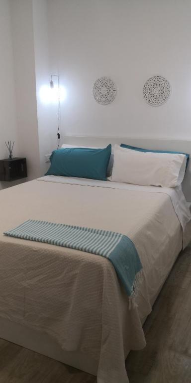 a bedroom with a large bed with blue and white pillows at Casa Playita de Luz in Barbate