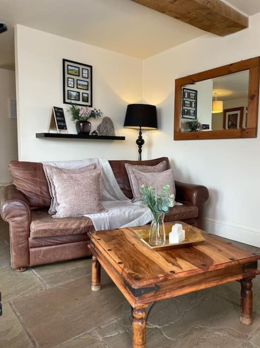 a living room with a couch and a coffee table at Daisy Cottage in Keighley