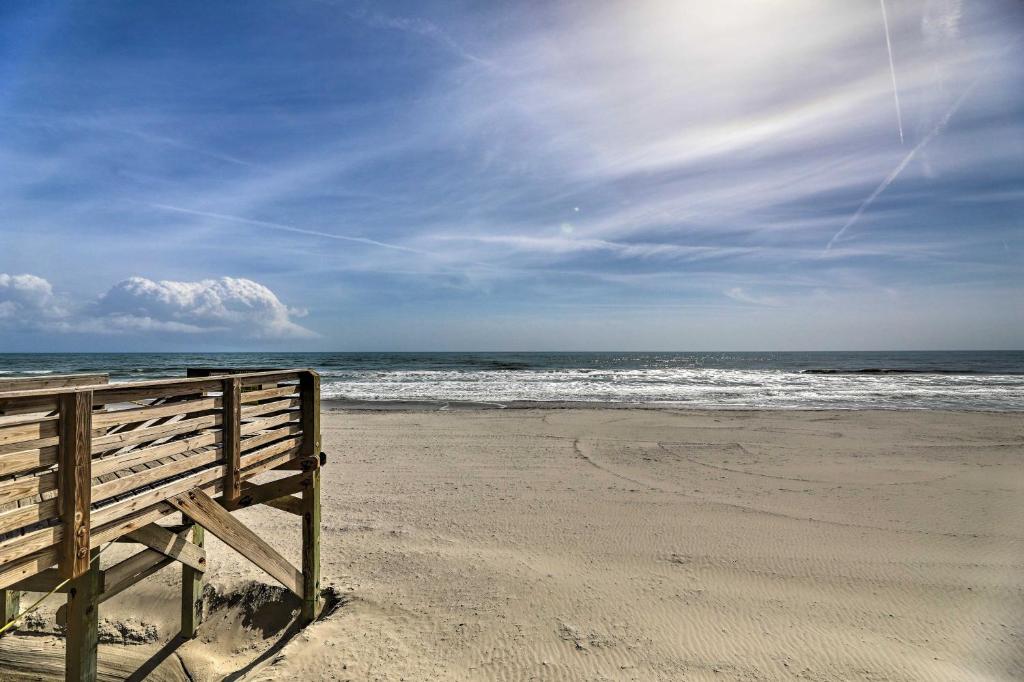 um banco de madeira sentado numa praia perto do oceano em Oceanfront North Topsail Beach Rental with Deck em North Topsail Beach