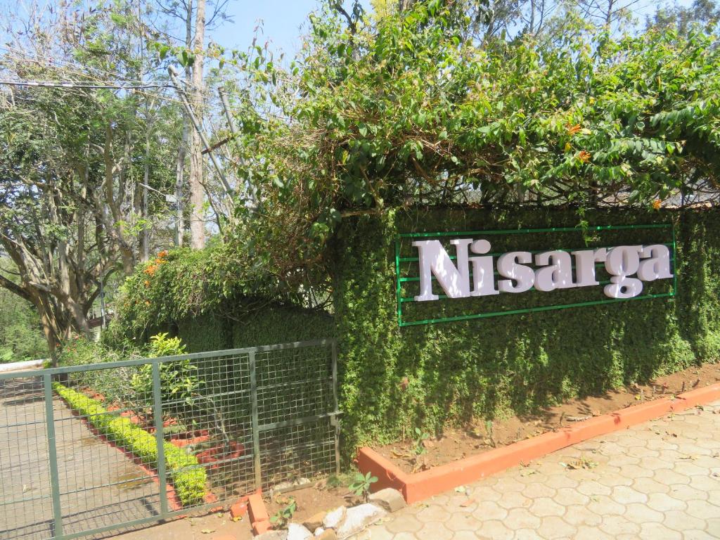 a sign for a nissari garden with ivy at NISARGA in Yercaud