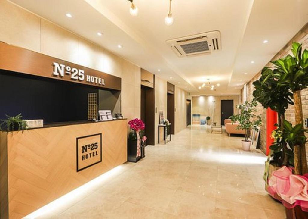 an office lobby with a reception desk and plants at NO25 Hotel Ansan in Ansan