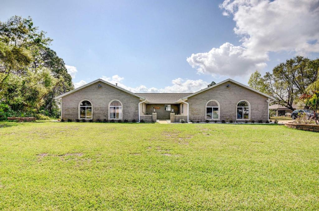 Waterfront Deltona Home with Pool and Screened Porch في دلتونا: أمامه منزل به حديقة كبيرة