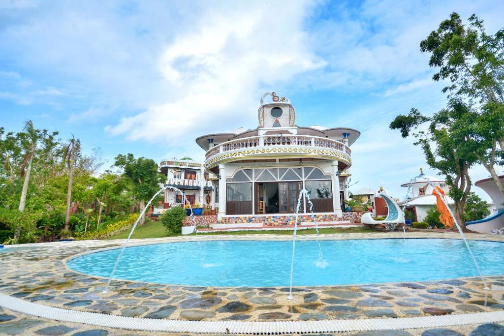 a large house with a swimming pool in front of it at Casa de Arte in Boracay