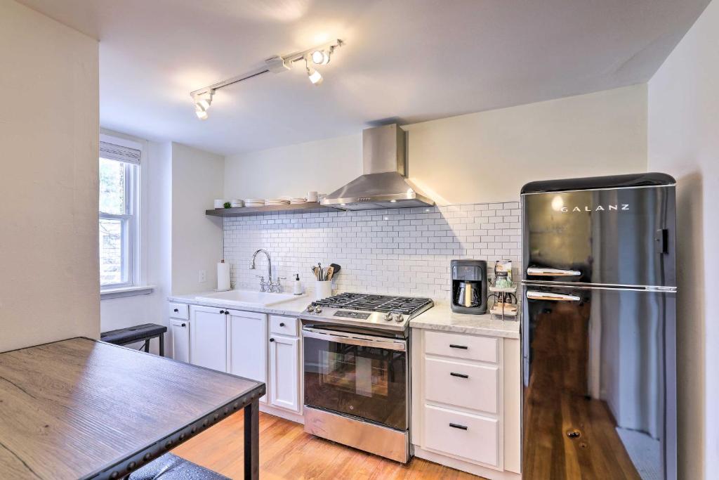 a kitchen with white cabinets and a stainless steel refrigerator at Cincinnati Vacation Rental 6 Mi to Downtown! in Cincinnati