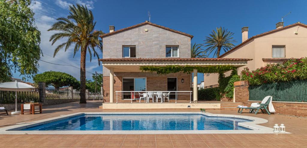 a villa with a swimming pool in front of a house at Apart-rent Villa Pani 0145 in Empuriabrava