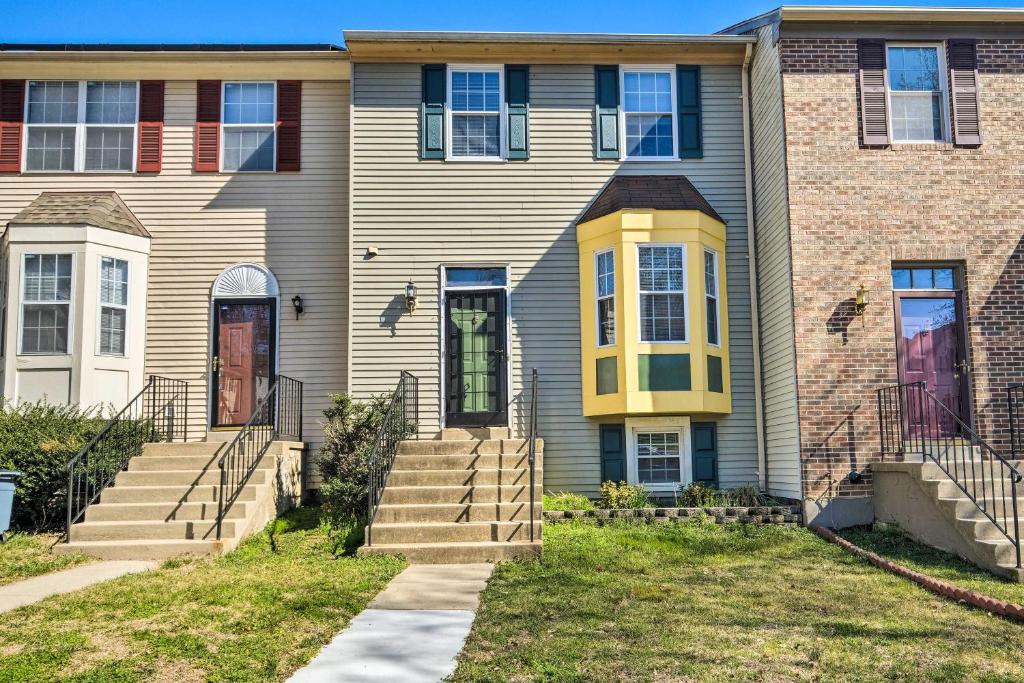 a house with a yellow door and stairs at Upper Marlboro Townhome with Washer and Dryer! in Largo