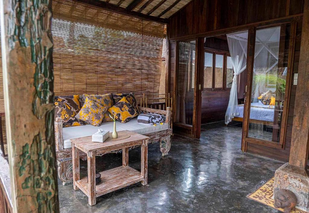 un soggiorno con divano e tavolo di Tano Home Villas ad Ubud