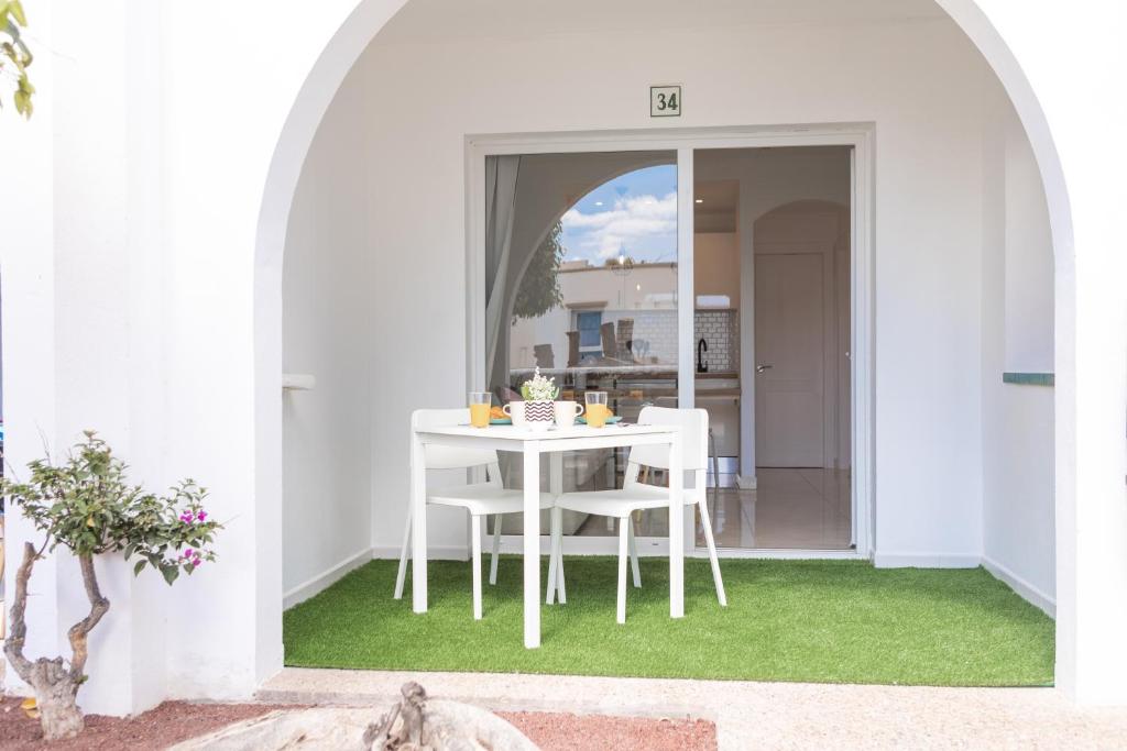 un comedor blanco con una mesa y sillas blancas en Naia House Lanzarote en Puerto del Carmen