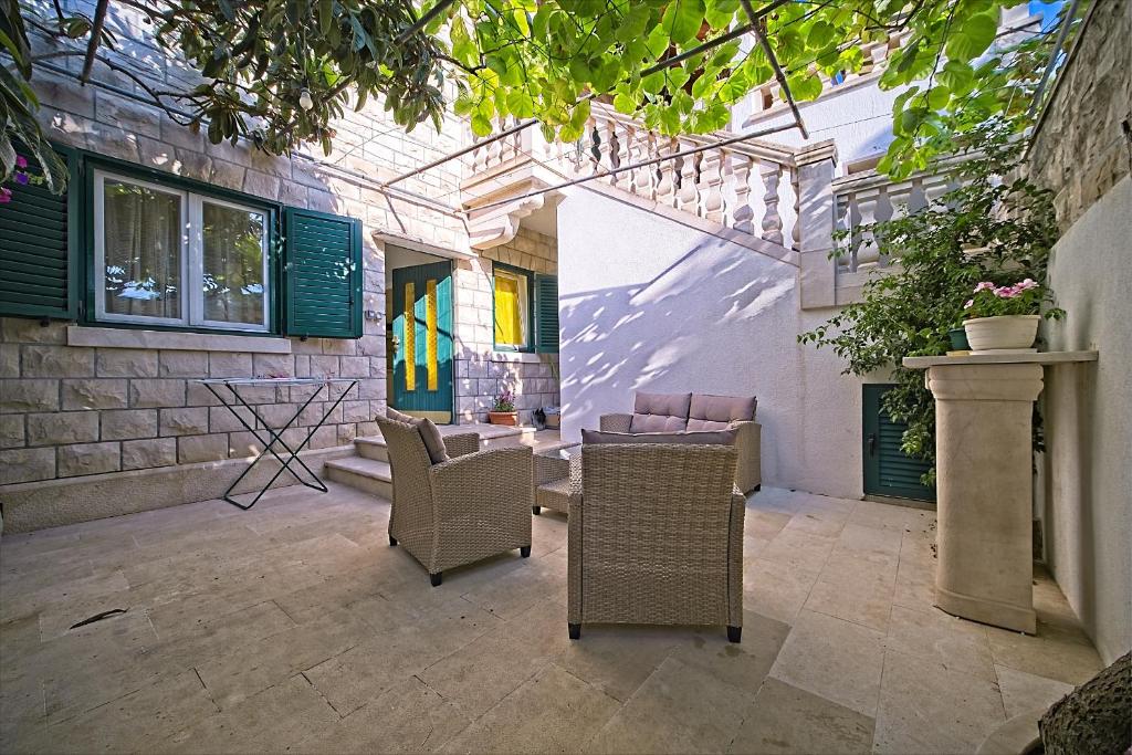 a patio with chairs and a table and a building at Apartment Renata in Postira