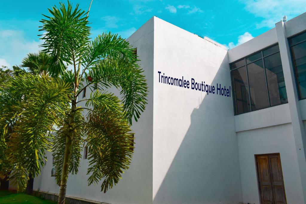 um edifício com uma palmeira em frente em Trinco Boutique Hotel em Trincomalee