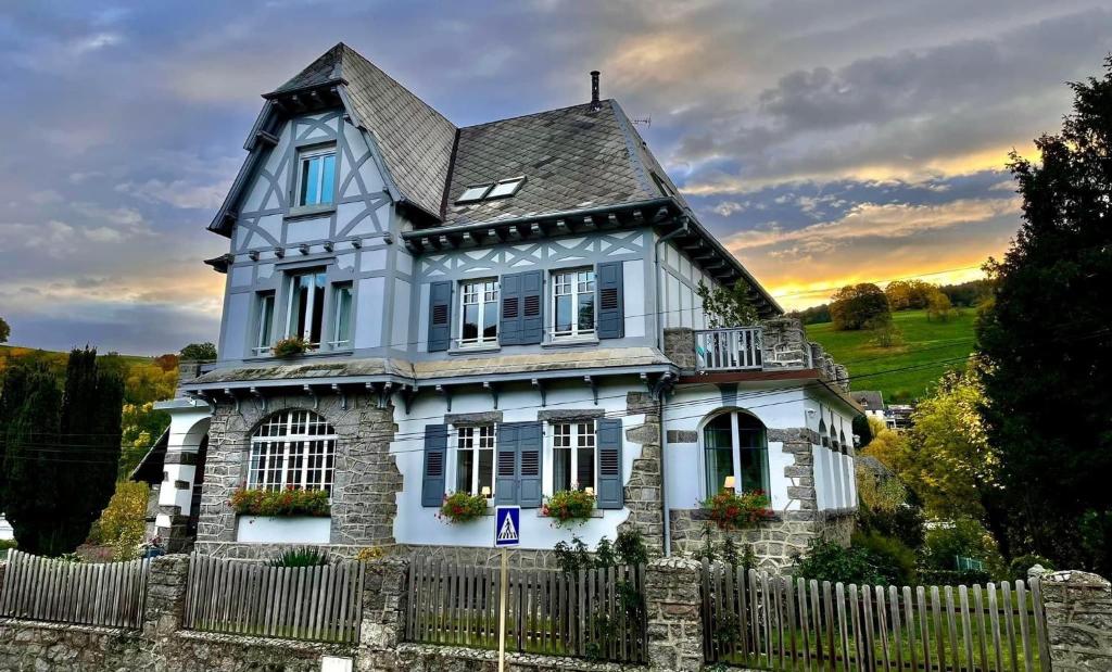 ein altes Haus mit einem Zaun davor in der Unterkunft Chambres d'hôtes Les Ecrins in Orbey