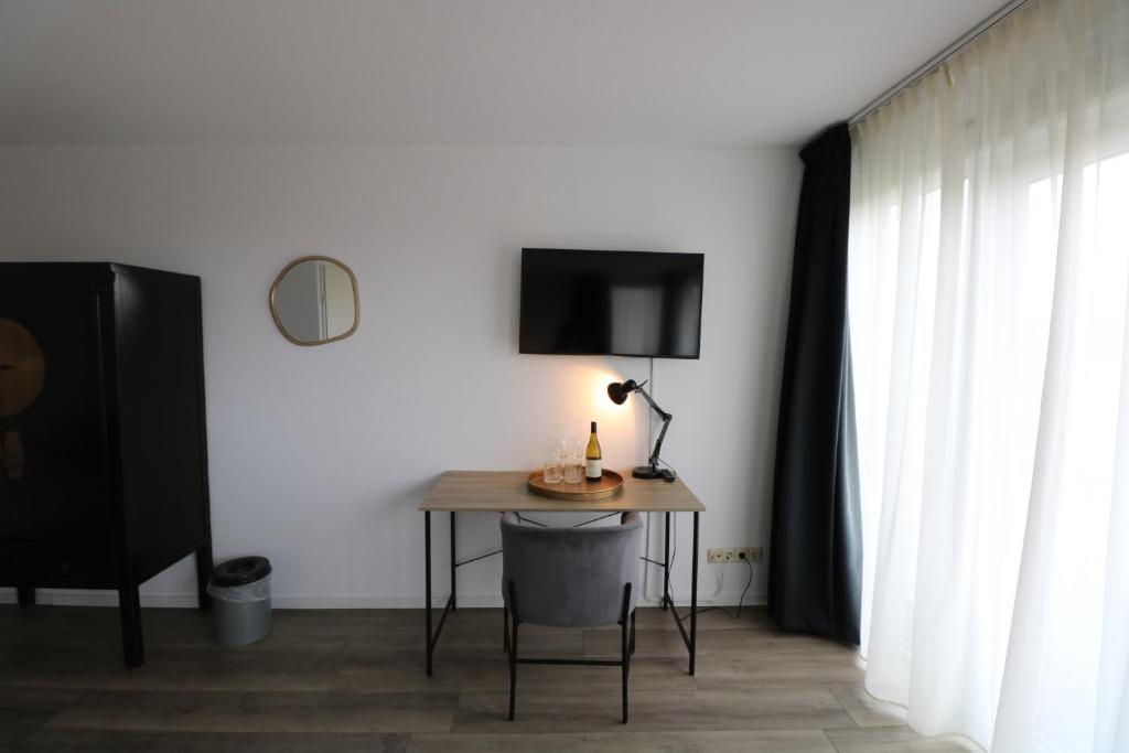 Zimmer mit einem Tisch mit einer Lampe und einem TV in der Unterkunft Seehotel Oostkapelle in Oostkapelle