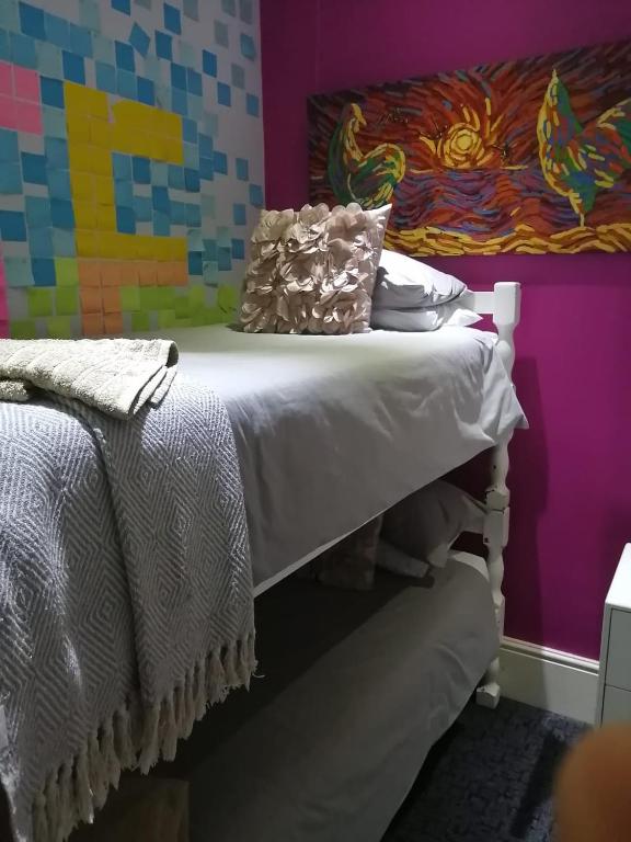 a bed in a room with a painting on the wall at Wild Artz 2 in Cape Town