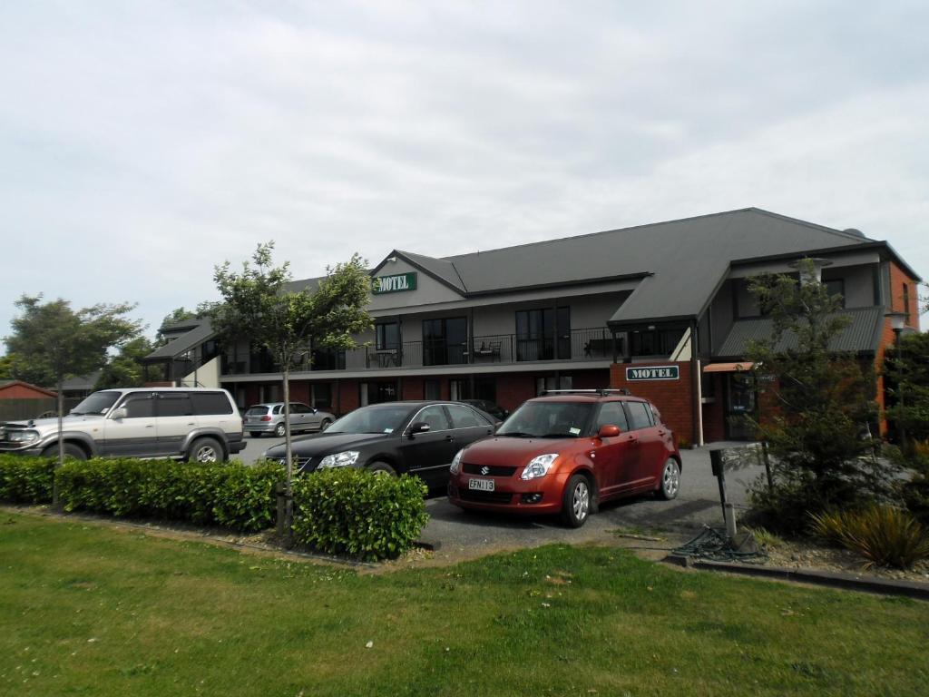 um carro estacionado num parque de estacionamento em frente a um edifício em Darfield Motel em Darfield