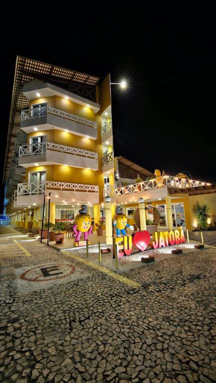Jatobá Praia Hotel في أراكاجو: مبنى به الكثير من الإشارات أمامه