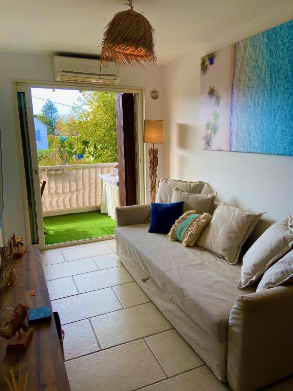 sala de estar con sofá y mesa en La Frégate - appartement à 100 m de la plage, en Saint-Cyr-sur-Mer