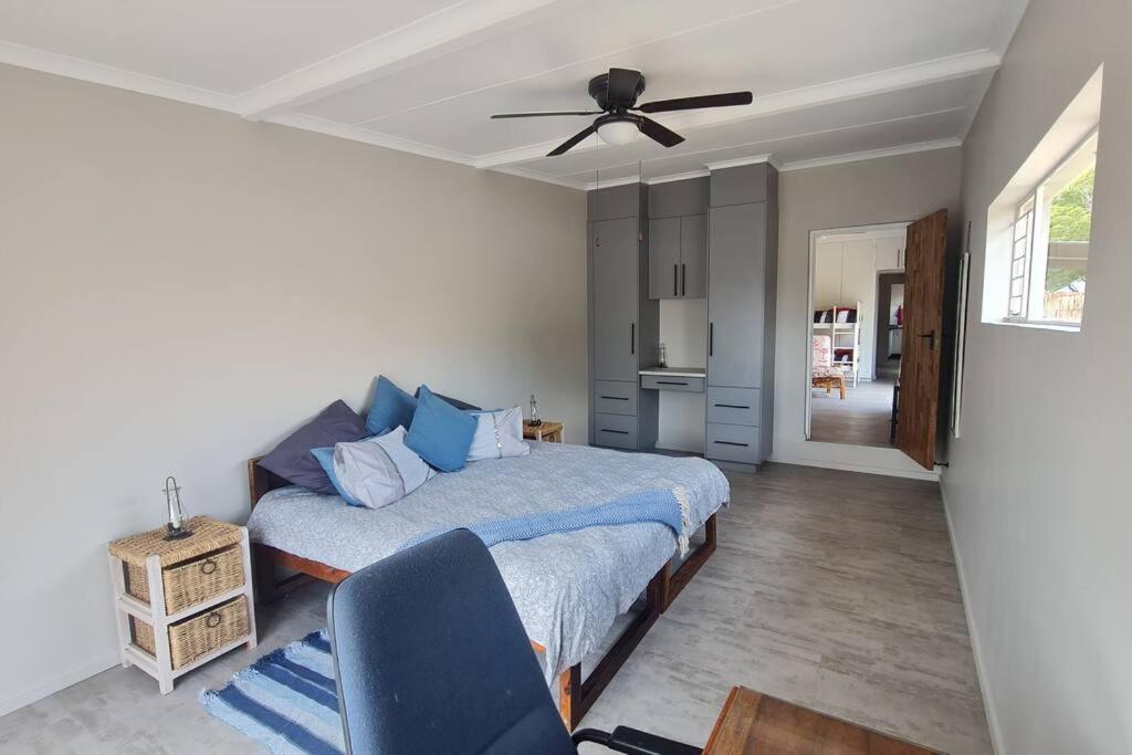 a bedroom with a bed and a ceiling fan at Rock away Beach Condo. in Hartenbos