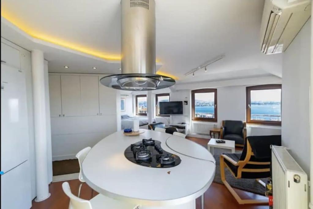 eine Küche und ein Wohnzimmer mit einem weißen Tisch und Stühlen in der Unterkunft ALİZE penthouse 360*view in Istanbul