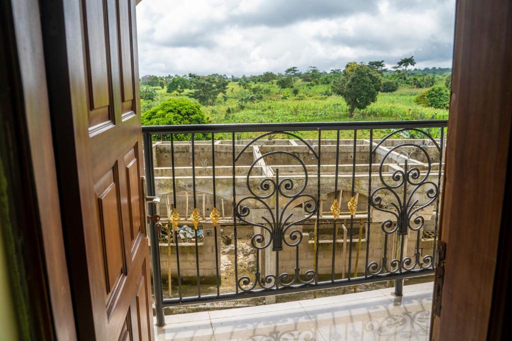 an open door to a balcony with a view of a field at Plan B Complex in Buea