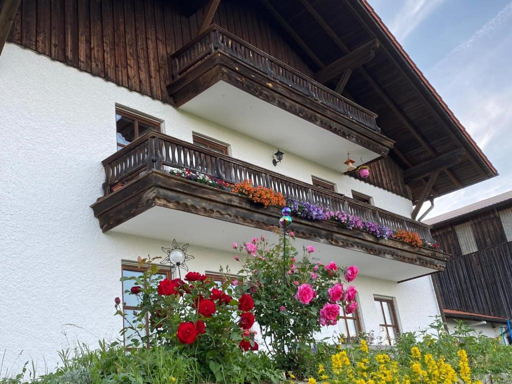 a balcony with flowers on the side of a building at Ferienwohnung Fernblick Breitenberg in Breitenberg