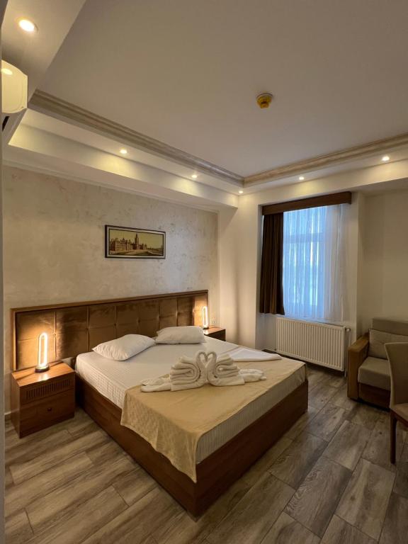 a bedroom with a large bed and a chair at Hotel EKA in Constanţa