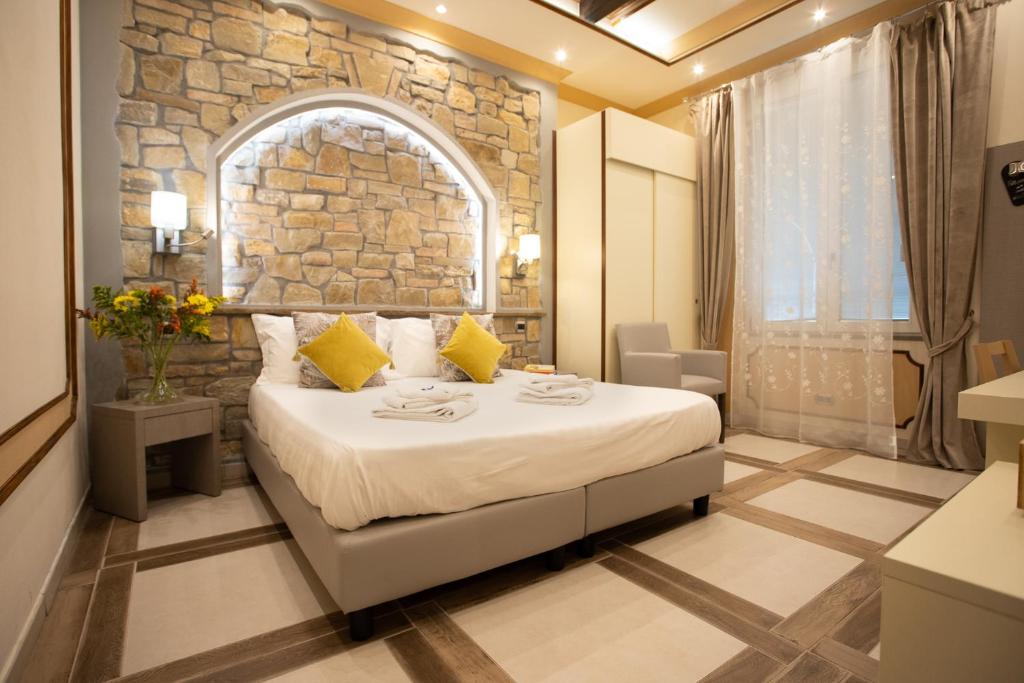 Habitación de hotel con cama y pared de piedra en Antica Piacenza, en Piacenza