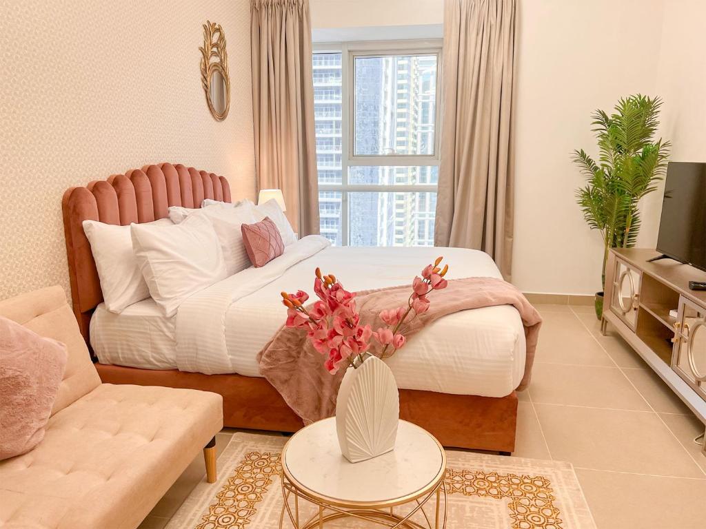 un soggiorno con letto e divano di Cosmos Living Cozy Studio Near Dubai Marina a Dubai