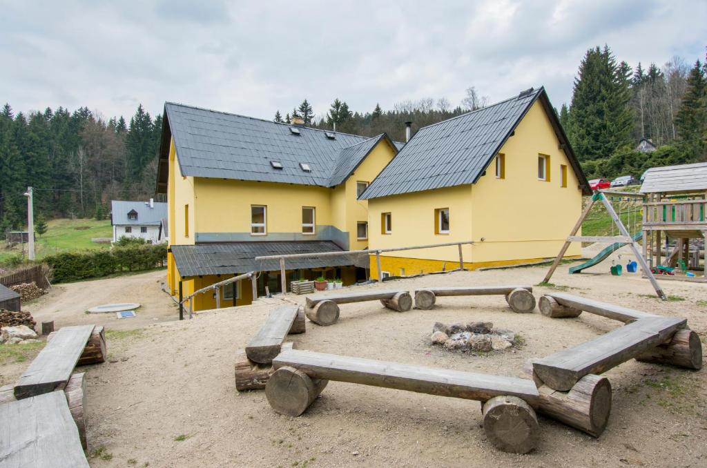 a yellow building with a playground in front of it at Chata U Skota in Janov nad Nisou