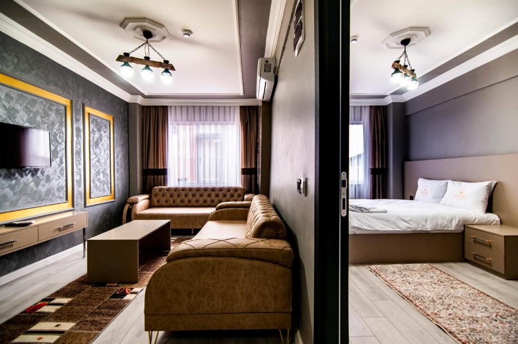 een hotelkamer met een bed en een bank bij Naif Bey Hotel in Istanbul