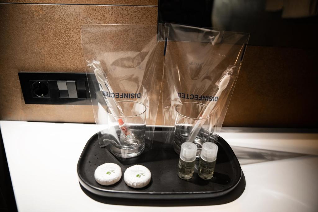 a black tray with glasses and bottles on a counter at MaLux Nis in Niš